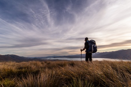 Silhouette of a hiker descending down from Stags Saddle in sunset, Lake Tekapo, New Zealandの写真素材