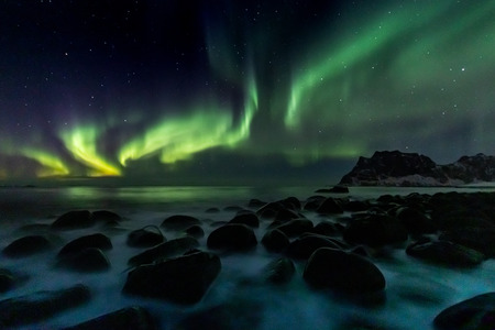 Beautiful green Northern Lights at Utakleiv Beach on the Lofoten Islands in Norwayの写真素材