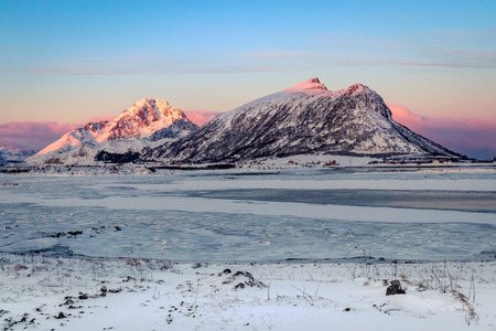 Morning light at a frozen fjord at Vestagoy on the Lofoten Islands in Norway in winterの写真素材