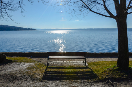 Enjoy the sun on a bench by the lake.の写真素材