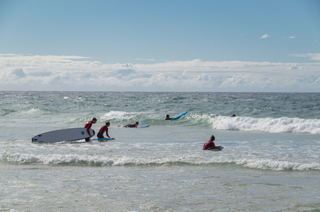 Gold Coast, Australia - July 11, 2017: surfers in the water at Surfers Paradise, a popular swimming and surfing spot.のeditorial素材