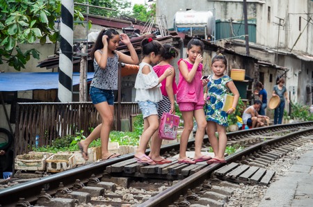 Hanoi, Vietnam - August 16, 2015: locals live their life on and around the train line passing between buildings in the Old Quarter of Hanoi.のeditorial素材