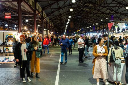 Melbourne, Australia - March 6, 2019: visitors in a market shed at the Queen Victoria Night Market, a weekly food and craft market during summer at the Queen Victoria Market.のeditorial素材
