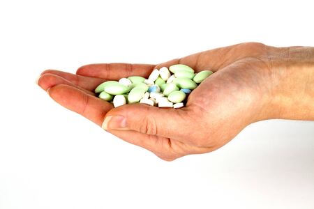 left hand with pills for healthcareの写真素材