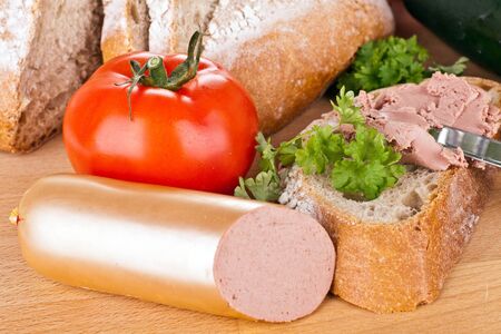 breakfast or lunch with mixed vegetables, sausage and a knifeの写真素材