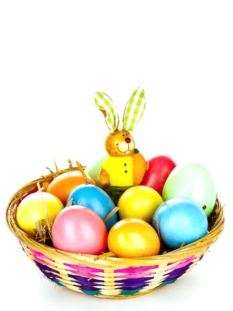 eastern eggs in different colours in a basket with a rabbitの写真素材