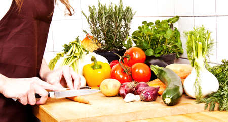young beautiful housewife is cooking with fresh vegetablesの写真素材