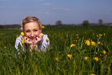 smiling woman outdoor in summer with flowersの写真素材