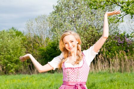 young woman with pink dirndl outdoor in summerの写真素材