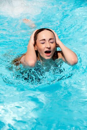 portrait of beautiful woman in summer in pool swimming holiday blue waterの写真素材