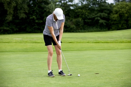 woman is playing golf on course  in summer in a golf-clubの写真素材