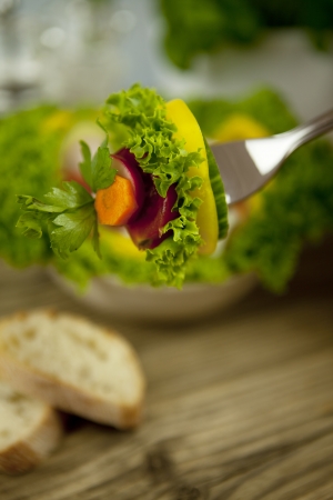 fresh tasty healthy mixed salad and bread on wooden tableの写真素材