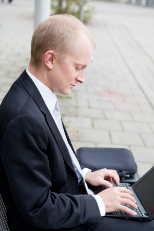 business man sitting outdoor working with notebook in summerの写真素材