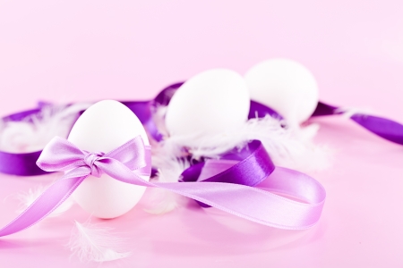 festive traditional easter egg decoration purple satin ribbon on pink の写真素材