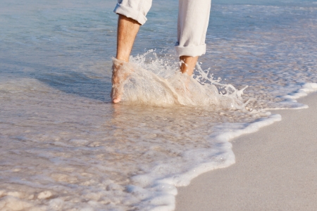 walking barefoot in the sand in summer holidays on beachの写真素材