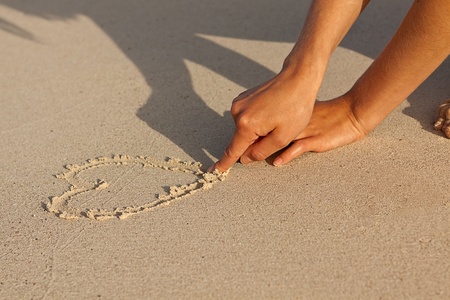 hand writing in sand in summer holiday vacation on beach の写真素材