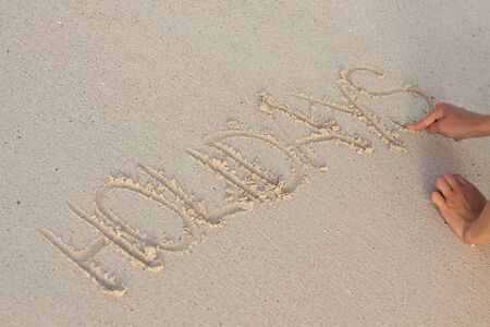 hand writing in sand in summer holiday vacation on beach の写真素材