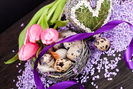 pink tulips and brown eggs with purple ribbon colorful easter decorationの写真素材