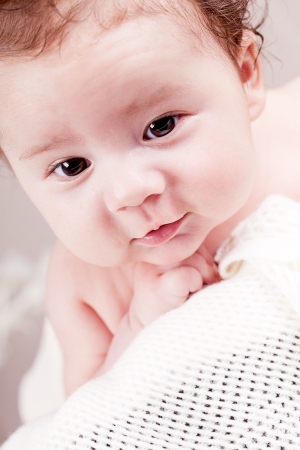 sweet little baby infant toddler on white  blanket in basket at homeの写真素材