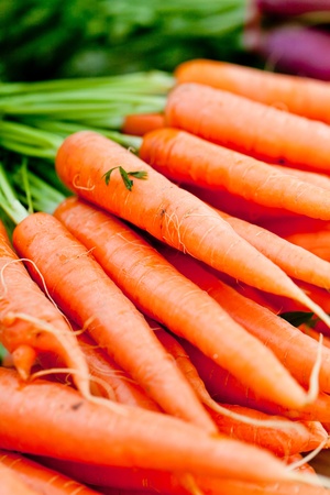 fresh orange carrot bundle on market in summer outdoorの写真素材