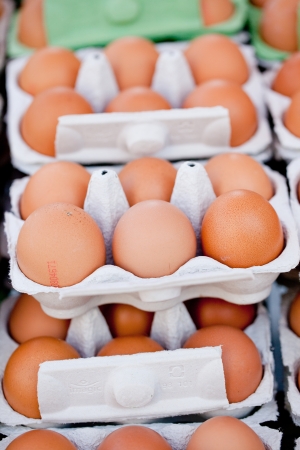 group of brown eggs in carton box closeup market outdoorの写真素材