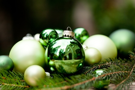 shiny green christmas baubles closeup macro and tree on wooden backgroundの写真素材