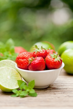 fresh tasty sweet strawberries and green lime outdoor in summer macro closeupの写真素材