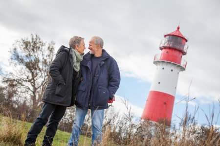 happy mature couple relaxing baltic sea dunes in autumnの写真素材