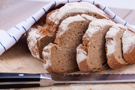 homemade fresh baked bread and knife on wooden table