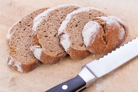 homemade fresh baked bread and knife on wooden table