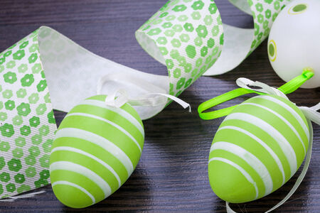 Collection of four hand decorated colourful green Easter eggs with different patterns displayed in...