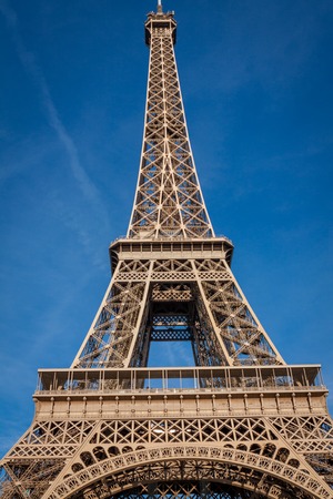 View of the Eiffel Tower in Paris on the Champs de Mars against a blue sky, one of the most visited...