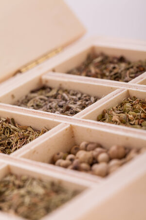 Overhead view of a tray with individual divisions displaying assorted dried spices and herbs for use in a kitchen to season and flavour food when cookingの写真素材
