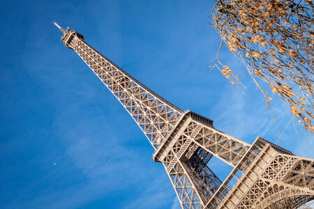 View of the Eiffel Tower in Paris on the Champs de Mars against a blue sky, one of the most visited and iconic landmarks in France with its distinctive wrought iron lattice frameの写真素材