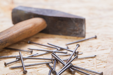 Mallet with nails and planks of new wood of varying thicknesses in a carpentry, joinery , DIY and...
