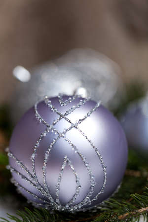 Silver Christmas ornaments in leaves with pine conesの写真素材