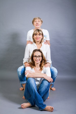 Three generations of attractive women with blond hair and a striking family resemblance posing...
