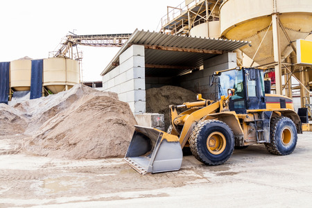 Parked pay loader near pile of dirt at a construction site