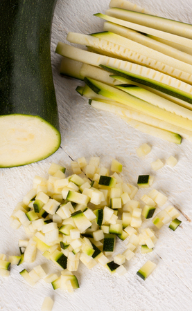 Fresh marrow or courgette cut into batons and diced into small cubes for use in salads and as a vegetable in cookingの写真素材