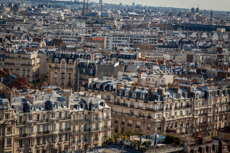 View over the rooftops of Paris, France with its streets of historical buildings to a distant skyline under a blue sky, travel conceptの写真素材