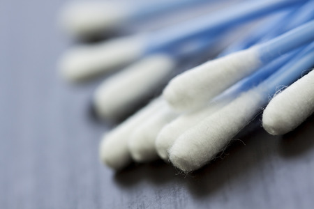 Random pile of blue plastic cotton ear buds for cleaning wax out of the ear in a health and hygiene conceptの写真素材