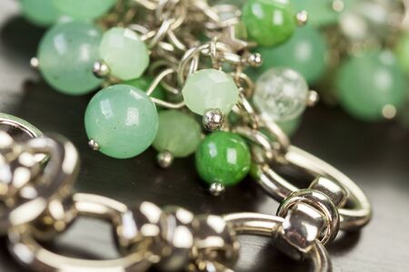 Close up view of pretty translucent green beads on an item of silver jewellery attached in a bunch...