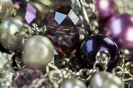 Close up of three attractive shiny purple beads attached by silver chains on an item of jewellery in a fashion and handicraft conceptの写真素材