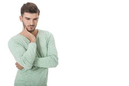 Puzzled handsome young man scratching his head with his hand as he looks at the camera with an uncertain perturbed expression, isolated on whiteの写真素材