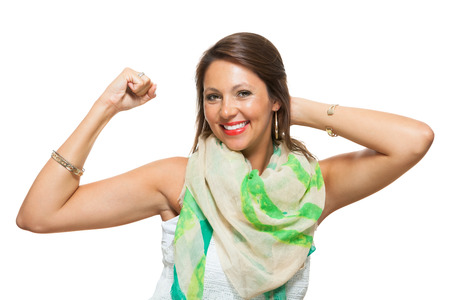 Close up Pretty Young Woman in Trendy Outfit, Showing her Arm Muscles While Holding Back Hair and Looking at the Camera. Isolated on White Background.の写真素材