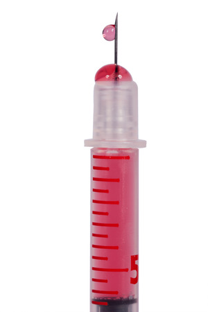 Disposable plastic hypodermic syringe and needle filled with a red solution for administering drugs subcutaneously or intramuscular isolated on whiteの写真素材
