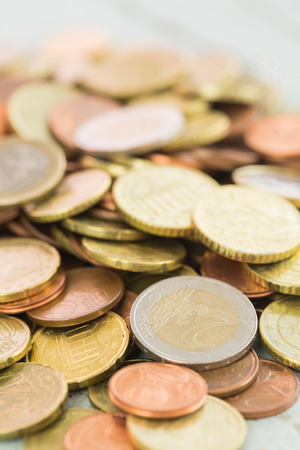 Heap of assorted Euro coins in different denominations in a vertical shallow dof view in a full frame financial backgroundの写真素材