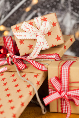 Close-up composition of Christmas present boxes of kraft paper with ribbons, decorations and stars patternの写真素材