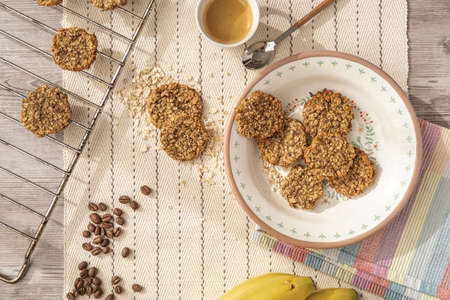 Top view of a freshly made oat cookies with espresso coffee and raw coffee beans.の写真素材