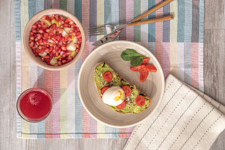 avocado toast with egg and a fruit bowl.の写真素材